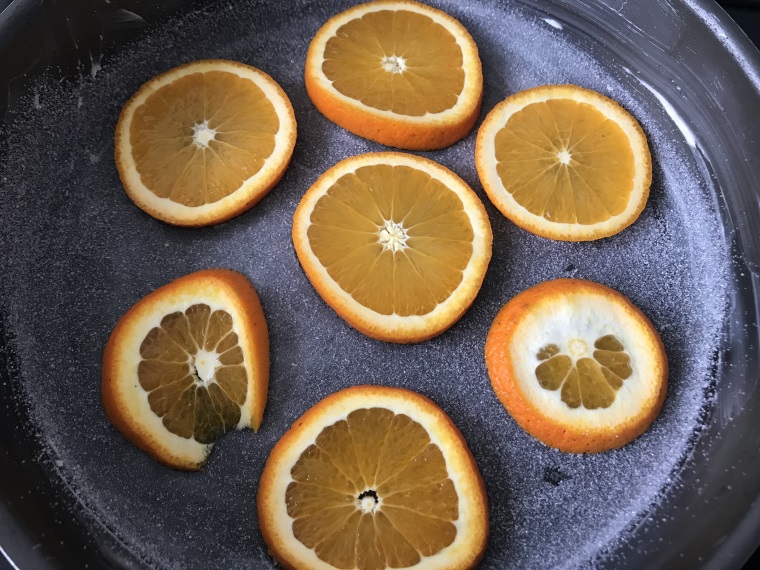 Tranches d'oranges sur le fond du moule beurré et saupoudré de sucre  en poudre